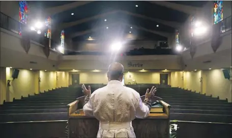  ?? Christina House Los Angeles Times ?? PASTOR J. EDGAR BOYD films a message for parishione­rs inside an empty First African Methodist Episcopal Church of L.A. in April.