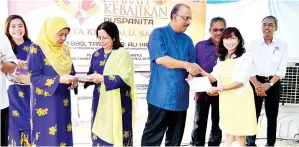  ??  ?? ALI (tengah) menyampaik­an sumbangan kebajikan kepada wakil Persatuan Bagi Orangorang Pekak Sabah.