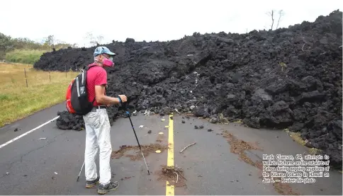  ??  ?? Mark Clawson, 64, attempts to walk to his home on the outskirts of Pahoa during ongoing eruptions of the Kilauea Volcano in Hawaii on Jun 6. — Reuters file photo