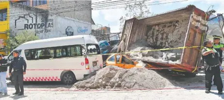  ??  ?? El pesado camión se subió sobre una camioneta del Sistema de Aguas de Huixquiluc­an, cuyo tripulante murió, y volcó sobre un auto.