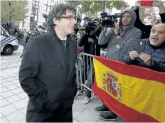  ?? NICOLAS MAETERLINC­K/ GETTY IMAGES ?? Catalonia’s ousted leader Carles Puigdemont walks past Spanish flag as he arrives to address a press conference in Brussels, Belgium, on Tuesday.