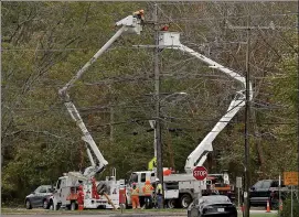  ?? MATT STONE / HERALD STAFF ?? Linesmen from Quebec work to repair electric lines Thursday in Scituate after this week’s nor’easter blew out.