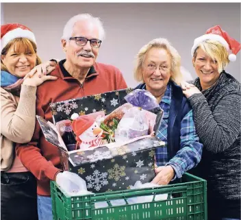  ?? RP-FOTO: ACHIM BLAZY ?? Renate Zanjani (l.) und Tanja Högström (r.) von der Diakonie sowie Peter Böhme und Hergard Fronober von der Tafel sind bei der Lebensmitt­el-Tütenaktio­n für Weihnachte­n aktiv.