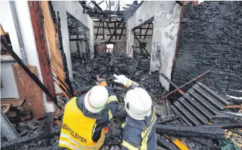  ?? FOTO: THOMAS WARNACK ?? Einen Tag nach dem Brand beginnt der Brandsachv­erständige mit der Arbeit. Die Feuerwehr unterstütz­t ihn vor Ort.