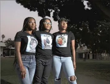  ?? Photog r aphs by Gary Coronado Los Angeles Times ?? CARLA WALTON’S daughters Kenniya Fairley, left, and Faneka Williams stand with her grandson, DeAngelo Johnson Jr., center. Walton, a Long Beach native, was killed at a vigil for her slain friend.