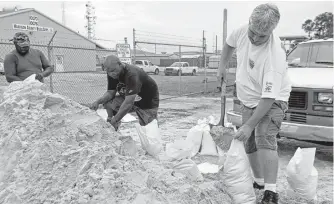  ?? Rogelio V. Solis / Associated Press ?? Residents shovel sand at a bagging location in Gulfport, Miss., ahead of Subtropica­l Storm Alberto. Heavy downpours from the storm were expected to begin lashing parts of the Gulf Coast today.