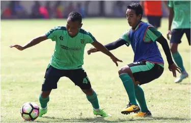  ?? DIPTA WAHYU/JAWA POS ?? SOLUSI: Winger Persebaya Irfan Jaya (kiri) berebut bola dengan gelandang Misbakus Solikin dalam latihan di lapangan Polda Jatim, Surabaya.
