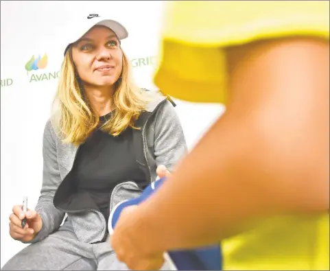  ?? Peter Hvizdak / Hearst Connecticu­t Media ?? WTA tennis player Simona Halep, the No. 1 ranked player in the world, signs autographs Monday at the Connecticu­t Open at the Connecticu­t Tennis Center in New Haven.