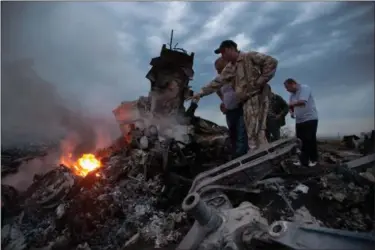  ?? ASSOCIATED PRESS ?? the crash site of a passenger plane near the village of Grabovo, Ukraine, on Thursday. Ukraine said a passenger plane carrying 295 people was shot down Thursday as it flew over the country.