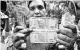  ?? PHOTO: PTI ?? A man shows new currency notes of ~200 and ~50 outside the RBI office in New Delhi on Friday