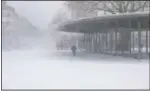  ?? (AP/Jonas Walzberg) ?? Snow blows from the roof of the bus station at the central station in Osnabrueck, Germany, on Sunday.