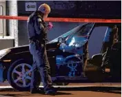  ?? TERRENCE ANTONIO JAMES/CHICAGO TRIBUNE ?? Police process a crime scene including a vehicle with multiple bullet holes in the 3100 block of West Lake Street in Chicago on March 19.