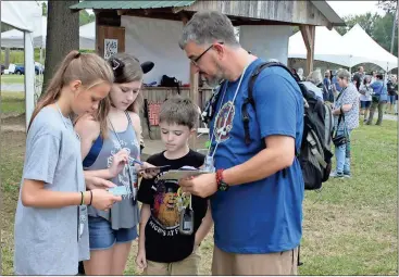  ?? Doug Walker / Rome News-Tribune ?? Geocaching is clearly a family event for Bailey Cook (from left) of Rome, and Kinsey, Hunter and Brent Cheshire, all from Hiram. They spent a lot of time checking out all the other cachers from all over the country here for the mega-event.