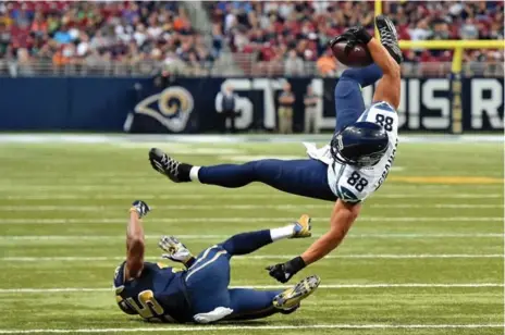  ?? JASEN VINLOVE/USA TODAY SPORTS ?? The Rams’ T.J. McDonald trips up Seahawks tight end Jimmy Graham during second-half action Sunday in St. Louis. The Rams upset Seattle in overtime.