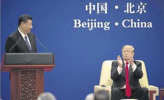  ?? AFP/NICOLAS ASFOURI ?? Donald Trump aplaude a Xi Jinping durante la rueda de prensa que ambos ofrecieron ayer en Pekín.