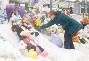  ?? GRAHAM HUGHES/THE CANADIAN PRESS ?? A woman places flowers at a makeshift memorial outside a daycare center Thursday in Laval, Quebec, where two young children were killed and six others were injured after a city bus slammed into the building this week. Pierre Ny St-Amand, a 51-year-old driver, faces two counts of first-degree murder and several other charges.