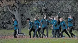  ?? CAMILLE FINE/CHICAGO TRIBUNE ?? The Jones College Prep cross-country girls team runs to the starting line to race in state sectionals Saturday at Lake Park East High School in Roselle.