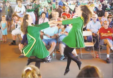  ?? Christian Abraham / Hearst Connecticu­t Media ?? Shannon Carrier, left, and Lydia Grillo, with the Mulkerin School of Irish Dance, perform a two- hands dance during the 13th annual Milford Irish Festival at the Fowler Field Pavilion in Milford on Saturday. The festival featured Irish music, dancing, culture, Gaelic football, food, drink and a variety of quality Irish wares for sale.