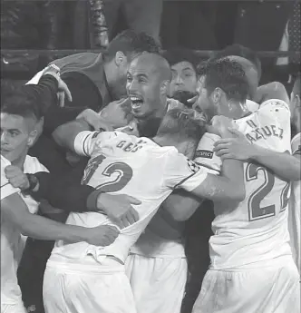  ?? MIGUEL MORENATTI, THE ASSOCIATED PRESS ?? Sevilla players celebrate after Guido Pizarro, centre, scored their third goal against Liverpool completing their three-goal comeback.