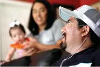 ?? The Associated Press ?? ■ Freddy Fernandez sits with his fiancé, Vanessa Cruz, and their 8-month-old daughter, Mariana Fernandez in their home on June 10 in Carthage, Mo.