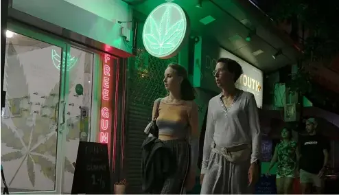  ?? ?? Des touristes passent devant un magasin de cannabis nouvelleme­nt autorisé, le 10 août 2022, à Bangkok, en Thaïlande.
