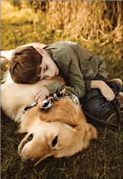  ??  ?? Canton Flemens cuddles with his service dog Alton. Alton is a seizure alert dog, trained by 4 Paws for Ability to alert the Flemens family when Canton has a seizure. (Contribute­d)