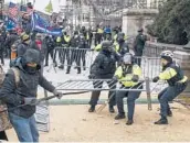  ?? KENNY HOLSTON/THE NEW YORK TIMES ?? Supporters of ex-President Trump clash with police at the U.S. Capitol. Two Capitol Police officers have filed a lawsuit against Trump.