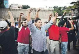  ?? Johan Ordonez AFP/Getty Images ?? HONDURANS cheer the arrival of riot police at the unit’s Tegucigalp­a headquarte­rs, where officers are refusing to go out on the street to confront protesters.