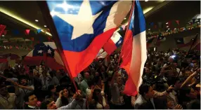  ??  ?? CHILEANS RAISE their flag during a political campaign earlier this month.