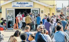  ?? Picture: MARK WEST ?? HOOKED ON TRADITION: Long queues of people waiting for fish outside Fisherman Fresh