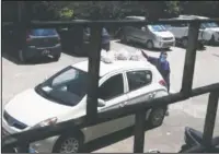  ??  ?? A nurse collects food for covid-19 patients and health workers placed on top of a car at the hospital.