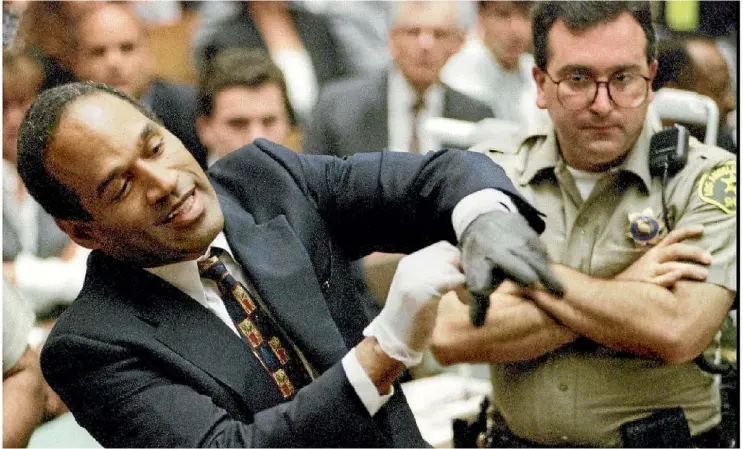 ??  ?? OJ Simpson wearing one of the stained gloves entered into evidence during his trial in 1995 when he was found not guilty on two counts of murder.