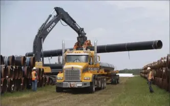  ?? JASON FRANSON, THE CANADIAN PRESS ?? Pipe is unloaded for the Line 3 pipeline replacemen­t project in Hardisty, Alta., on Thursday.