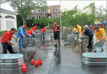  ?? TANIA BARRICKO—DAILY FREEMAN ?? The Kingston Volunteer Firemen’s Museum team, left, went up against the Kiwanis Club for a friendly bucket brigade competitio­n. The Kiwanis Club won, filling their trough with 7 1⁄2 inches of water to the Firemen’s Museum 5 1⁄2 inches. Despite Saturday’s rain, the 15th Annual Antique Fire Engine Muster and Open House went on with antique fire trucks on display which later drove to the Spring Lake Fire Department for a reception.The Volunteer Firemen’s Hall and Museum on Fair Street in Uptown Kingston, where the event took place, was open to the public throughout the day.