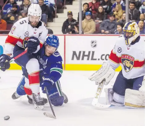  ?? ARLEN REDEKOP ?? Panthers defenceman Aaron Ekblad staves off the Canucks centre Bo Horvat as Panthers goaltender Roberto Luongo keeps watch during Sunday’s game at Rogers Arena. Luongo was sharp but his former team dominated, skating to a convincing 5-1 victory.