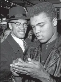  ?? AP PHOTO ?? In this March 1, 1964, file photo, world heavyweigh­t boxing champion, Muhammad Ali, right, is shown with Black Muslim Leader, Malcolm X, outside the Trans-Lux Newsreel Theater on Broadway at 49th Street in New York City. They had just watched a...