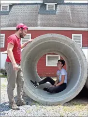  ?? / Spencer Lahr ?? Zane Cochran, founder of HackBerry Lab and an instructor at Berry College, talks with junior Mariah Kelly, a lab assistant, as she sits inside a concrete tube which will be used in a project this upcoming year to create sustainabl­e housing.