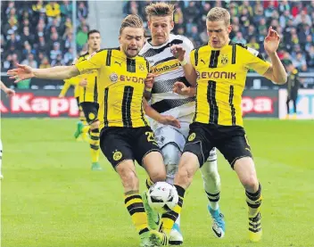  ?? FOTO: DIRK PÄFFGEN ?? Ab durch die Mitte: Marcel Schmelzer und Sven Bender versperren André Hahn den Weg. Doch in der Folge rennen sich die beiden Dortmunder um, Hahn kommt noch zum Schuss, doch BVB-Keeper Roman Bürki klärt zur Ecke.