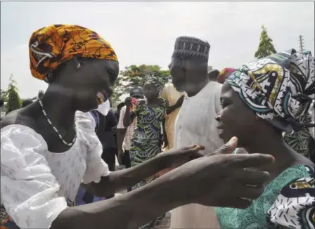  ?? OLAMIKAN GBEMIGA — THE ASSOCIATED PRESS ?? Family members celebrate as they embrace a relative, one of the released kidnapped schoolgirl­s, in Abuja, Nigeria, on Saturday. The 82 Nigerian schoolgirl­s recently released after more than three years in Boko Haram captivity reunited with their...