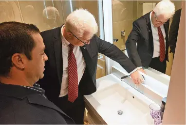  ?? PICTURE: COURTNEY AFRICA ?? SHUT IT OFF: Economic Opportunit­ies MEC Alan Winde tests a tap at the SunSquare City Bowl Hotel that automatica­lly cuts of the flow of water. With him is Yasser Domingo, the hotel’s maintenanc­e manager.