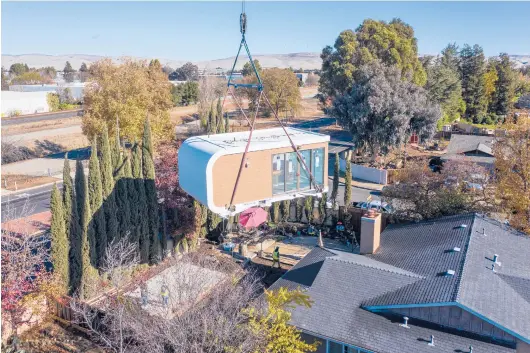  ?? MIGHTY BUILDINGS ?? A 3D-printed housing module is delivered in Livermore, California. Mighty Buildings’ modules are usually transporte­d to the owner’s property, then put into place using a crane.