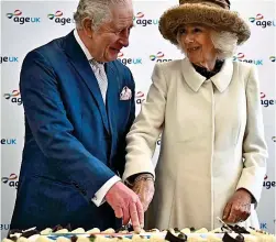  ?? ?? Slice of the action: Charles and Camilla cut a cake yesterday