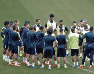  ?? Andre Penner/Associated Press ?? O técnico Tite conversa com jogadores da seleção antes de treino nesta segunda-feira (27)