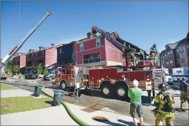  ?? (NWA Democrat-Gazette/ Andy Shupe) ?? Fayettevil­le firefighte­rs (above photo) check the roof for fire Tuesday after a fire broke out at Village at Shiloh Park Land apartments in Fayettevil­le. (Left photo) Firefighte­rs work on the roof. Go to nwaonline. com/210616Dail­y/ for today’s photo gallery.