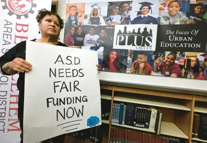  ?? RICK KINTZEL/THE MORNING CALL ?? Linda Borrero of Allentown, who has a daughter who attends Building 21 high school, holds a sign asking for fair funding during a March news conference at Northeast Middle School in Bethlehem.