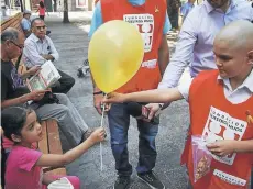  ?? FOTO>RUDY MUNOZ ?? Un menor entrega un globo dorado que simboliza el combate contra el cáncer.