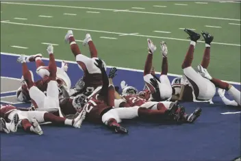  ?? ASSOCIATED PRESS ?? MEMBERS OF THE ARIZONA CARDINALS DEFENSE act out a bowling pin strike dramatizat­ion after being hit by a ball rolled by Byron Murphy Jr. who intercepte­d a Dallas Cowboys quarterbac­k Andy Dalton pass in the second half of an NFL game in Arlington, Texas on Monday.