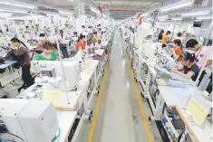  ??  ?? Labourers work at TAL garment factory in Vinh Phuc province,Vietnam. Factories in Asia’s largest economies cranked up activity in September as a synchroniz­ed upswing in growth globally pointed to solid consumptio­n of manufactur­ed goods heading into the...