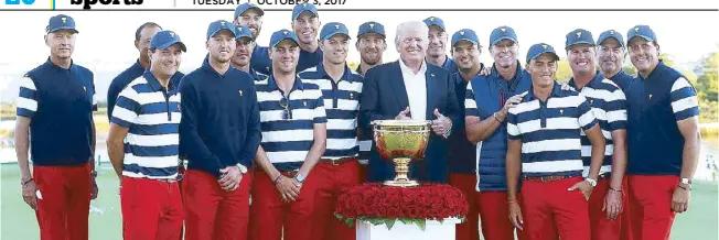  ?? AFP ?? US President Donald Trump poses with the US Team and the trophy after the Americans defeated the Internatio­nal Team in the Presidents Cup at the Liberty National Golf Club in Jersey City, New Jersey.