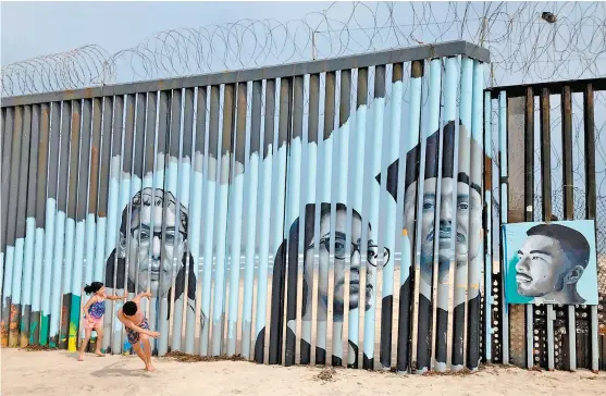  ?? ELLIOT SPAGAT/ AP ?? Retratos de mexicanos deportados colocados en la frontera de Tijuana con San Diego.